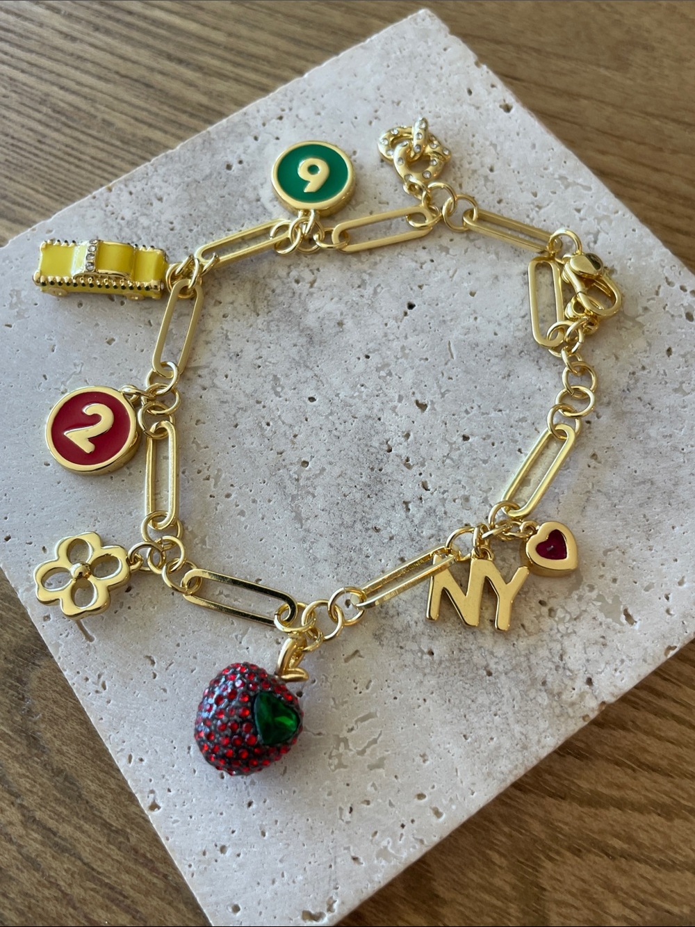 kate spade gold tone charm bracelet with colorful enamel & red strawberry charm